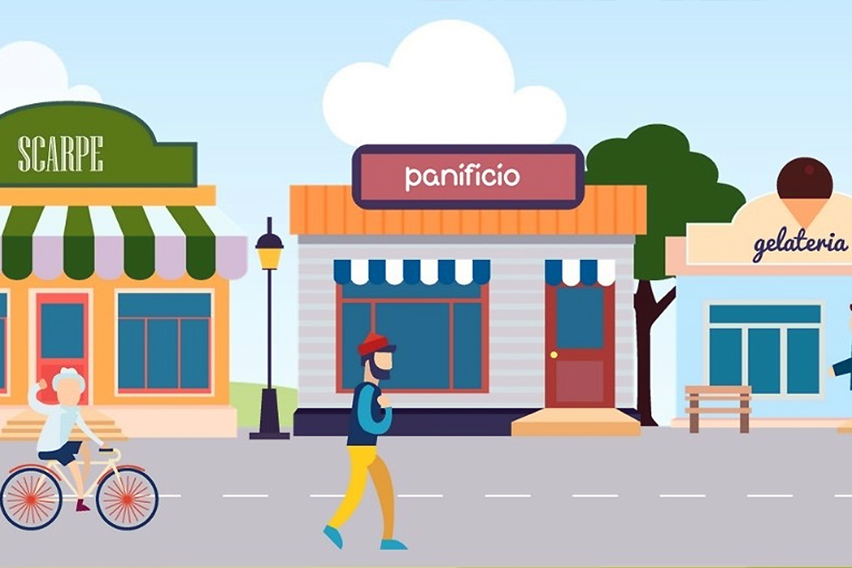 dalla strada si vedono un bambino in bicicletta un uomo che passeggia e sullo sfondo, un panificio al centro, una negozio di scarpe sulla sinistra ed una gelateria sulla destra.